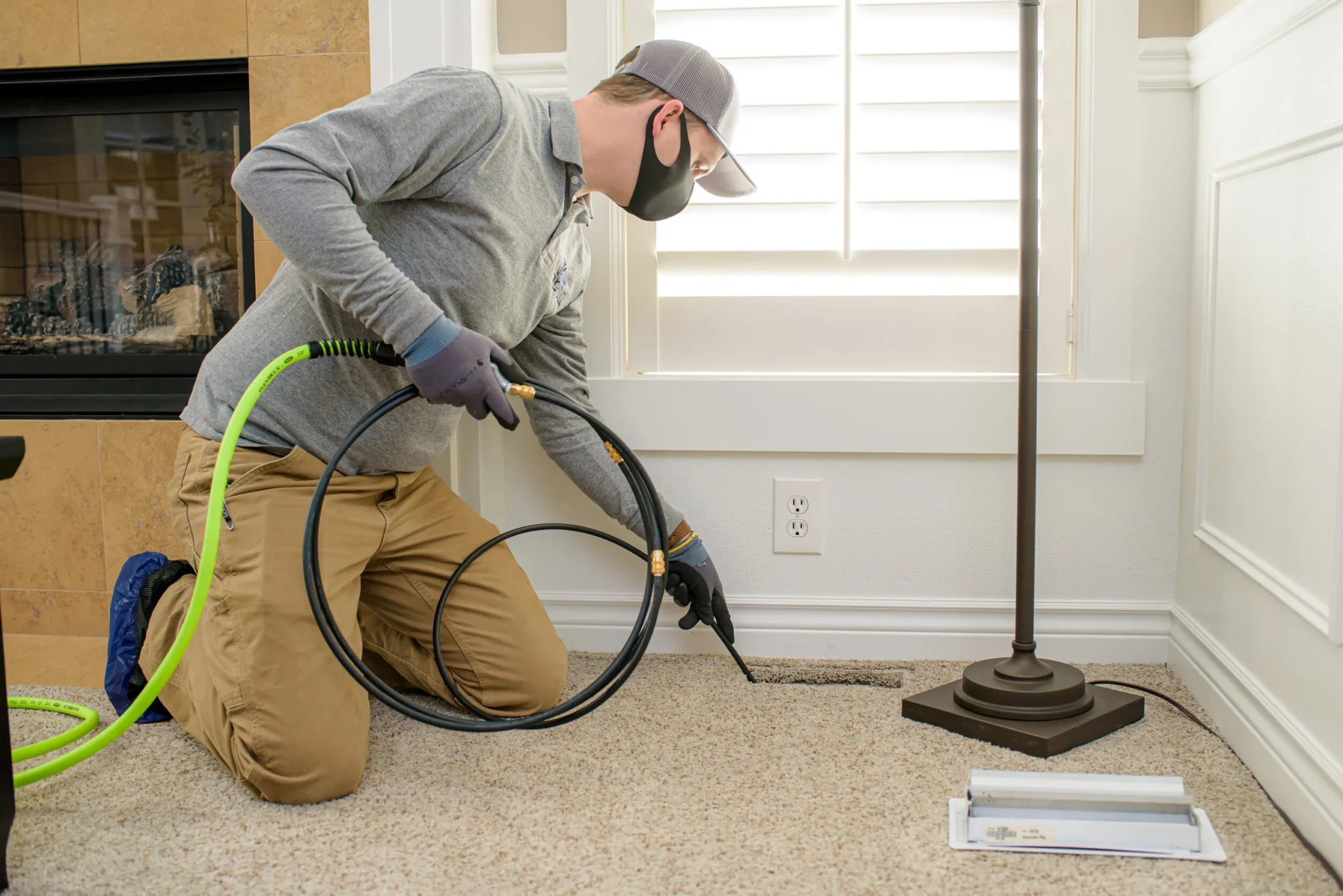 technician cleaning floor vent in kansas city home living room