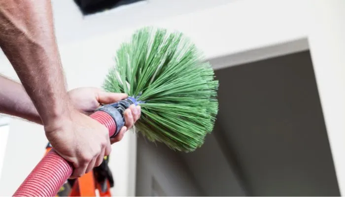 technician using brush to clean dryer vent in kansas city home