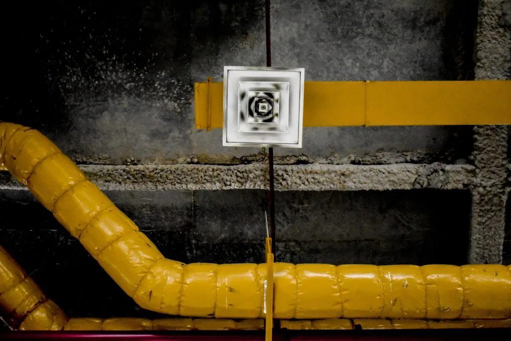technician inspecting air duct system in kansas city industrial facility