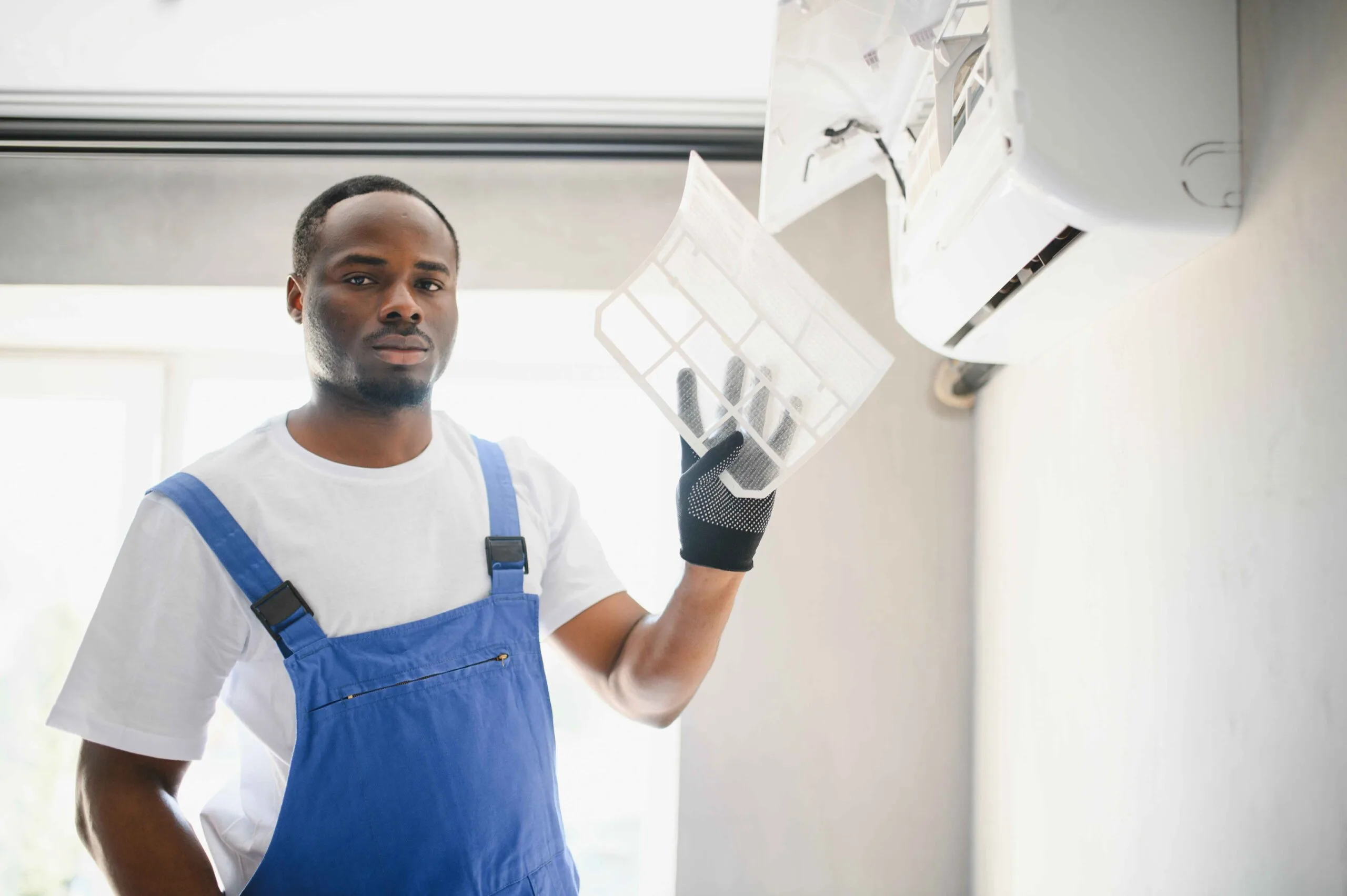 technician holding a clean HVAC filter in a kansas city home
