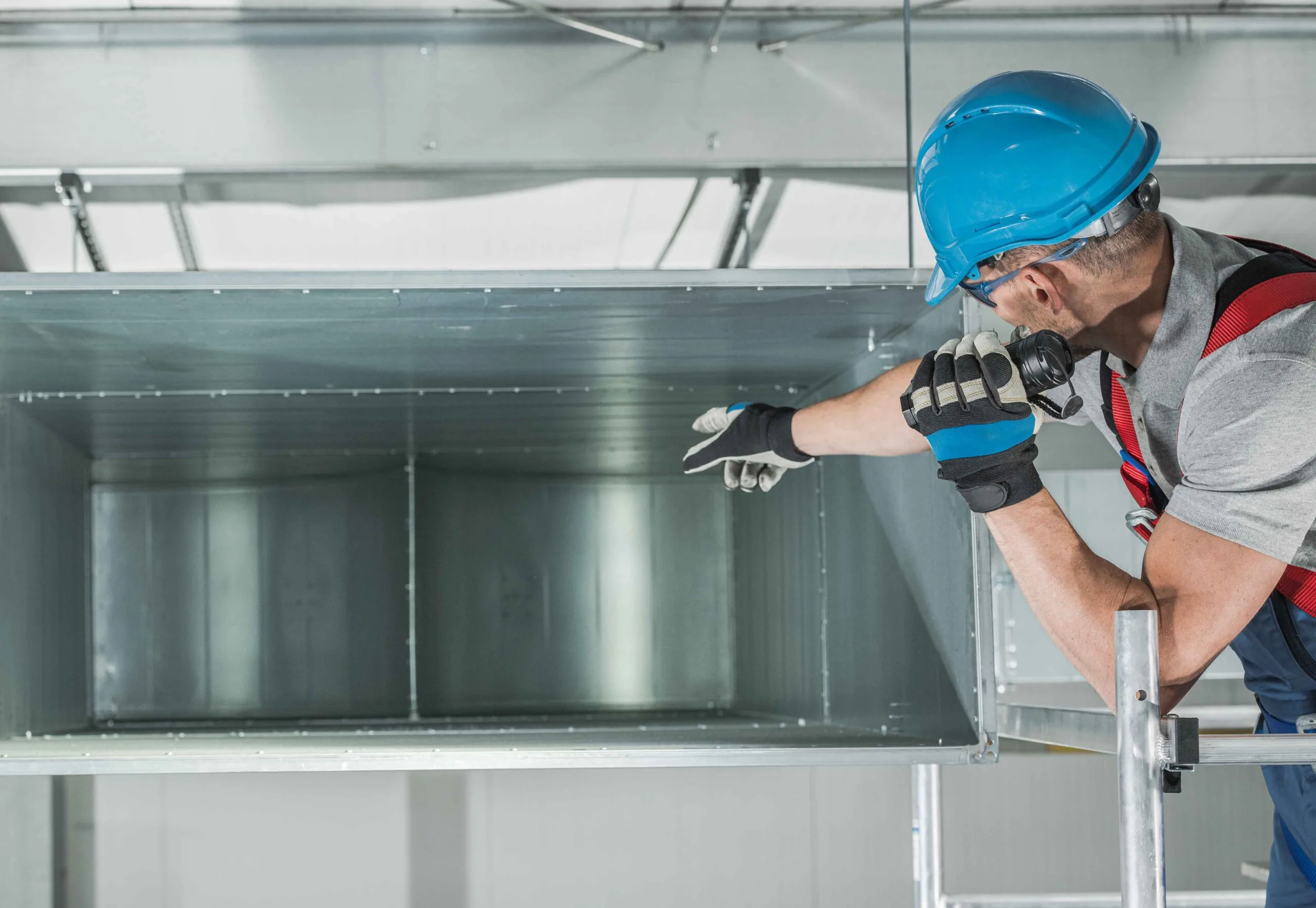 technician inspecting clean air duct in commercial building near lees summit mo