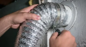 technician securing flexible dryer vent hose in kansas city home