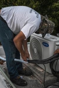 Professional technician performing air duct sanitization service in a home