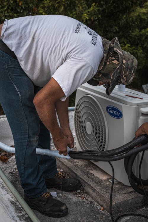 HVAC technician performing fall maintenance inspection on residential heating system